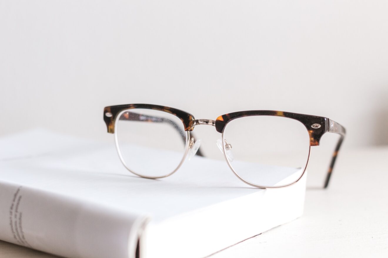 Pair of reading glasses resting on real estate clauses and contract documents
